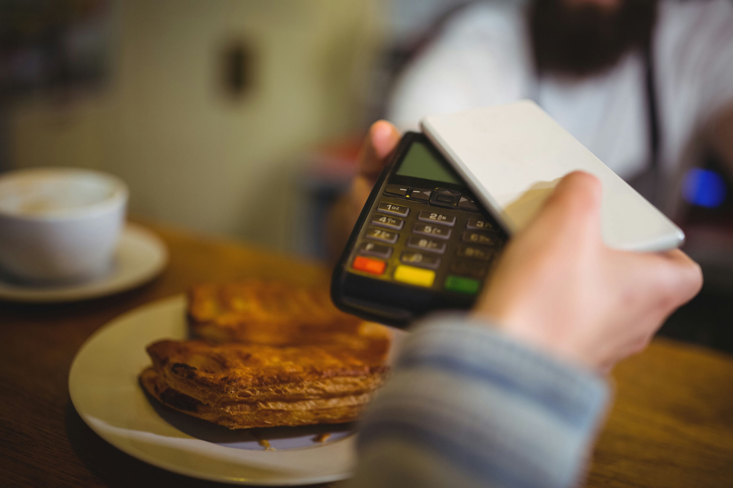 woman-paying-bill-through-smartphone-using-nfc-technology